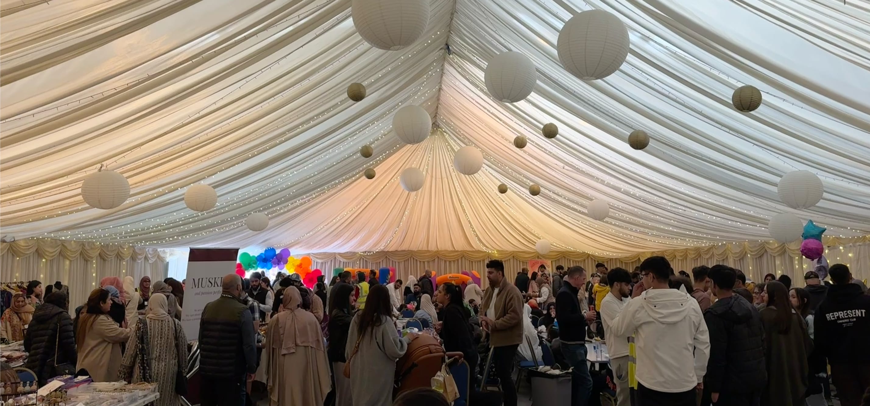 An image inside the beautifully-decorated marquee showing families browsing the stalls.